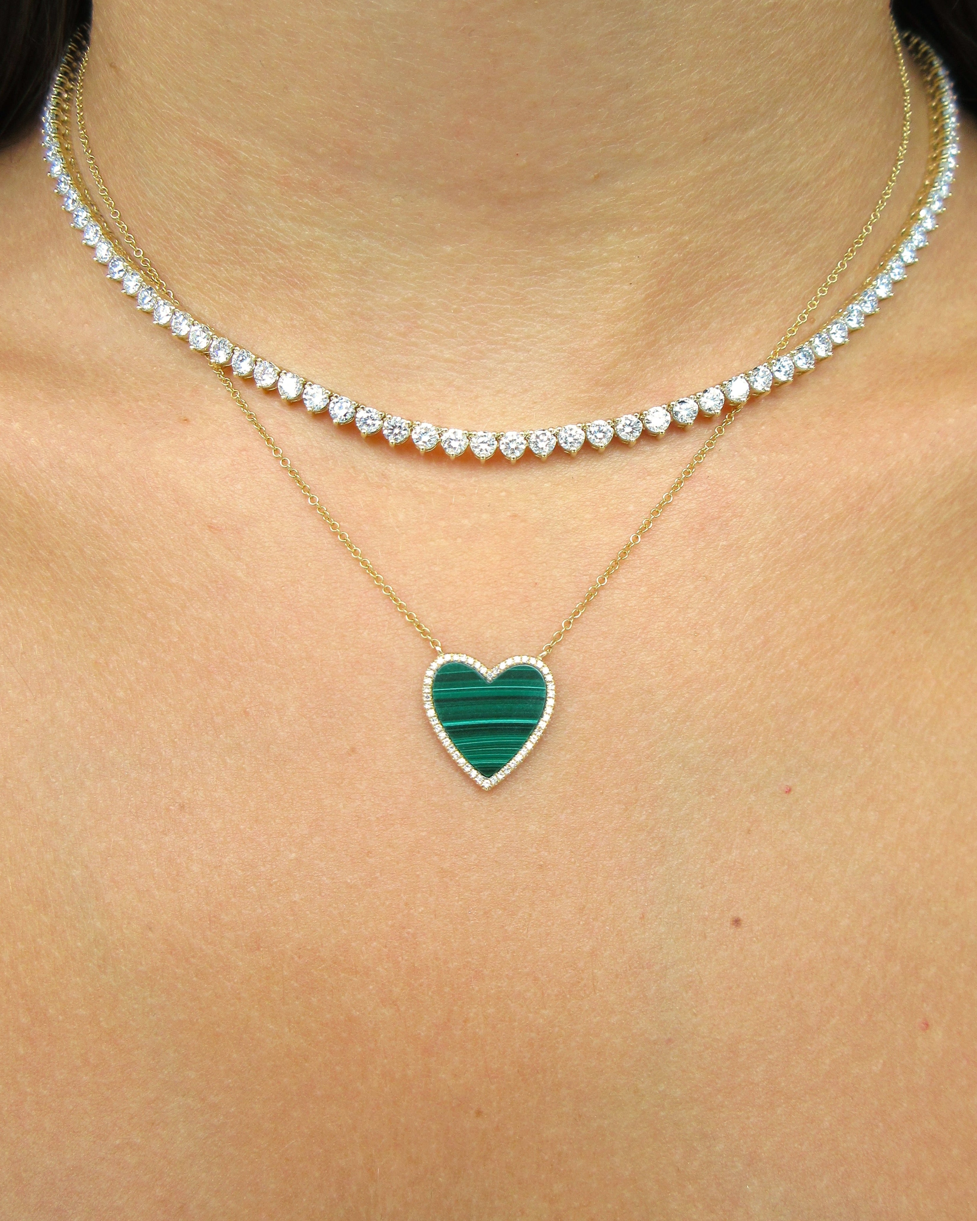 Necklace with a heart-shaped malachite pendant on a person's neck