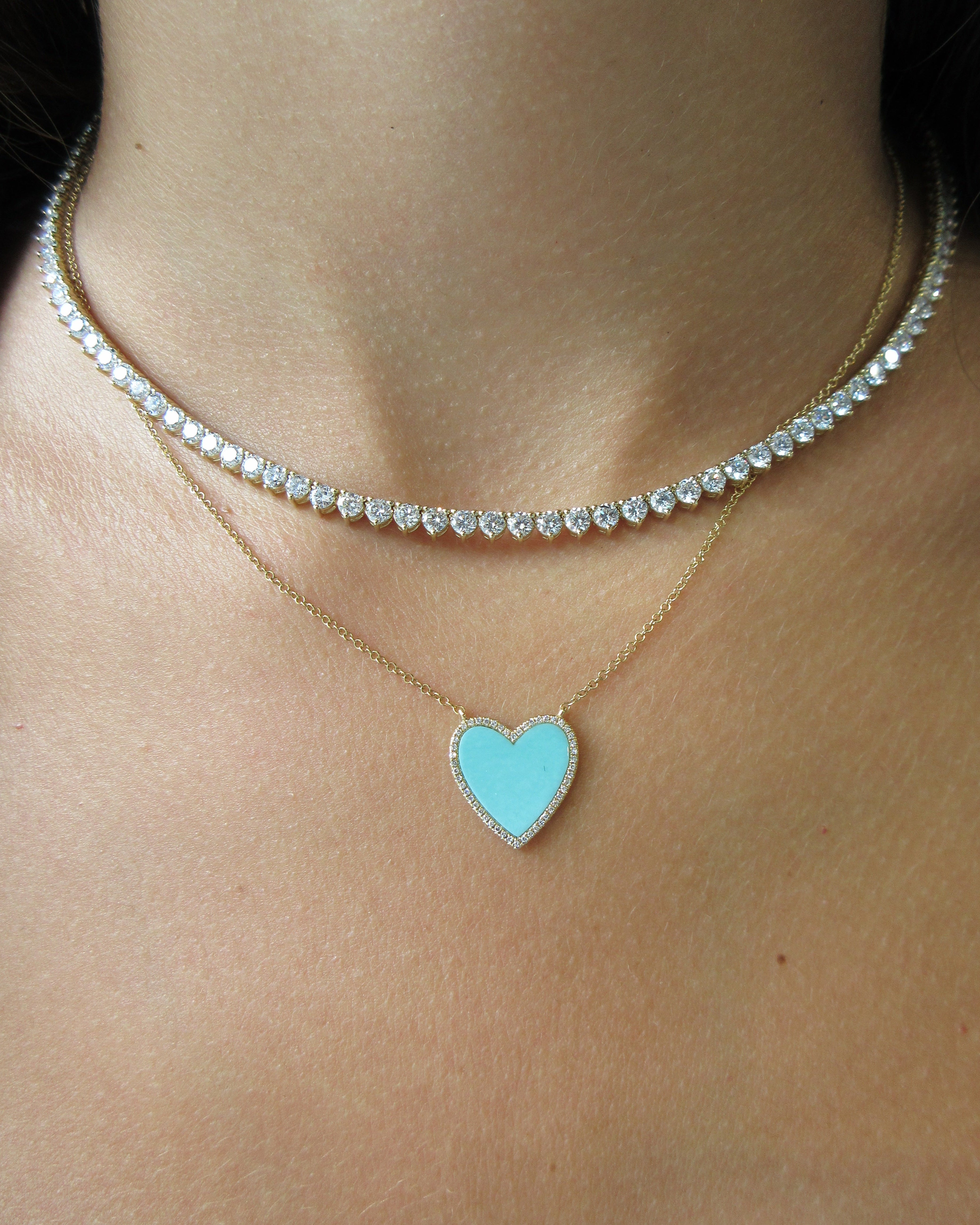 Necklace with a heart-shaped pendant on a person's neck