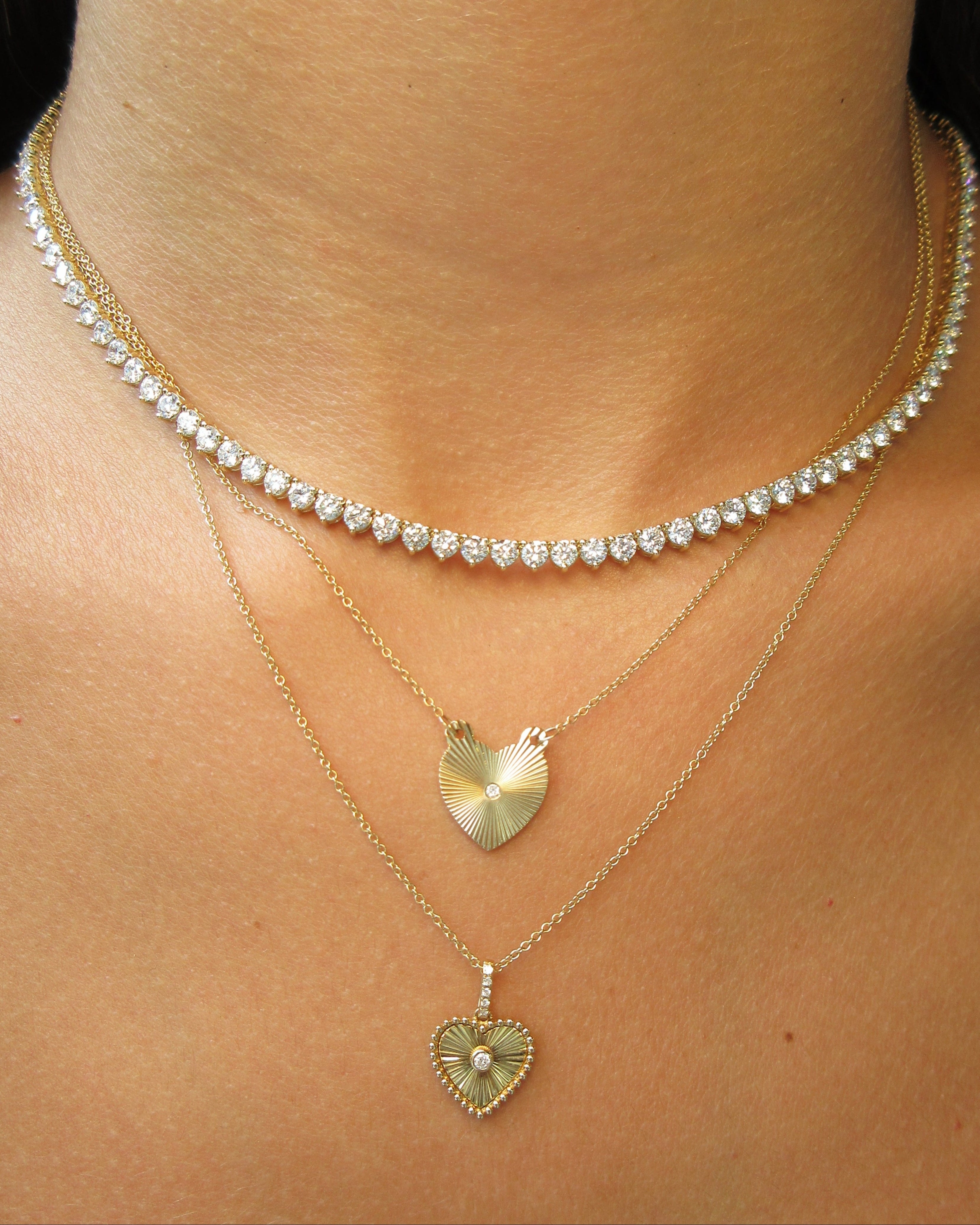 Gold necklace with heart-shaped pendants on a person's neck