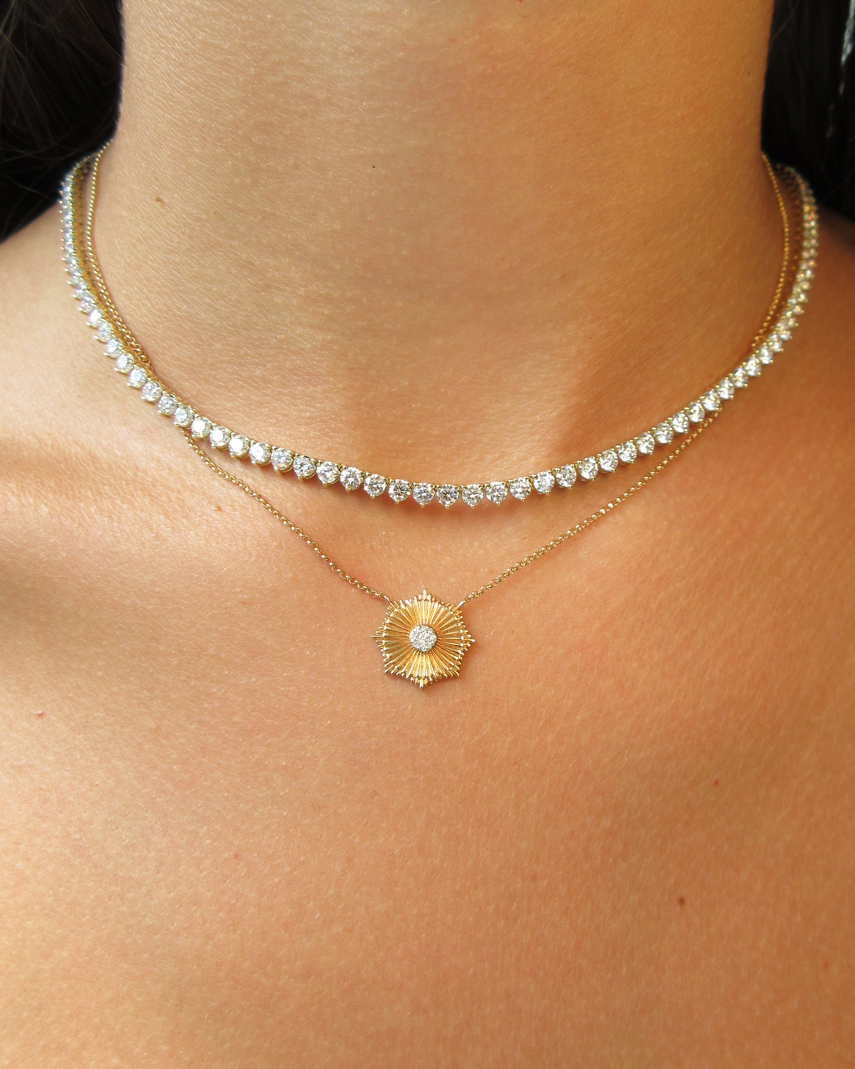 Gold and diamond necklace on a person's neck