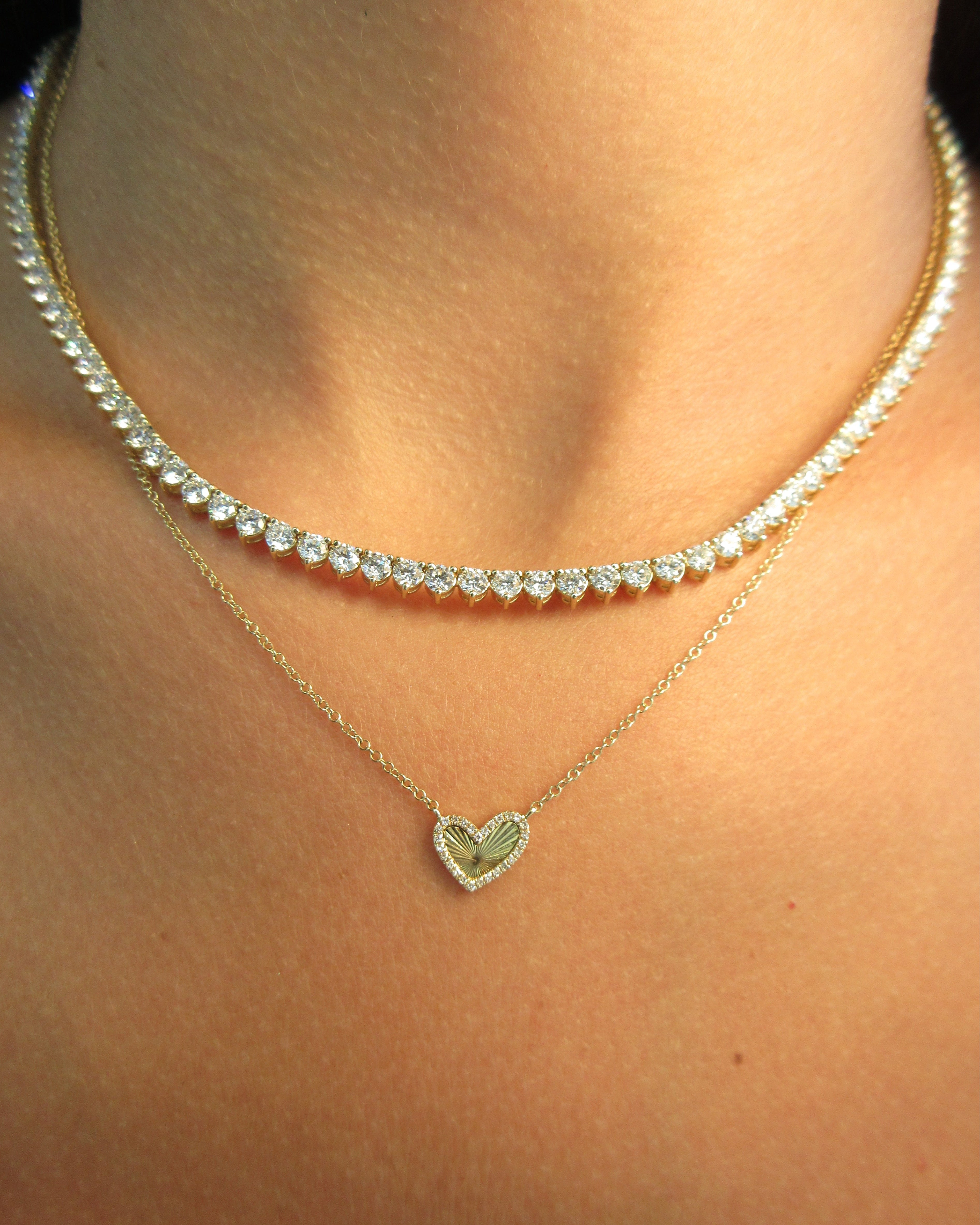 Necklace with a heart-shaped pendant on a person's neck