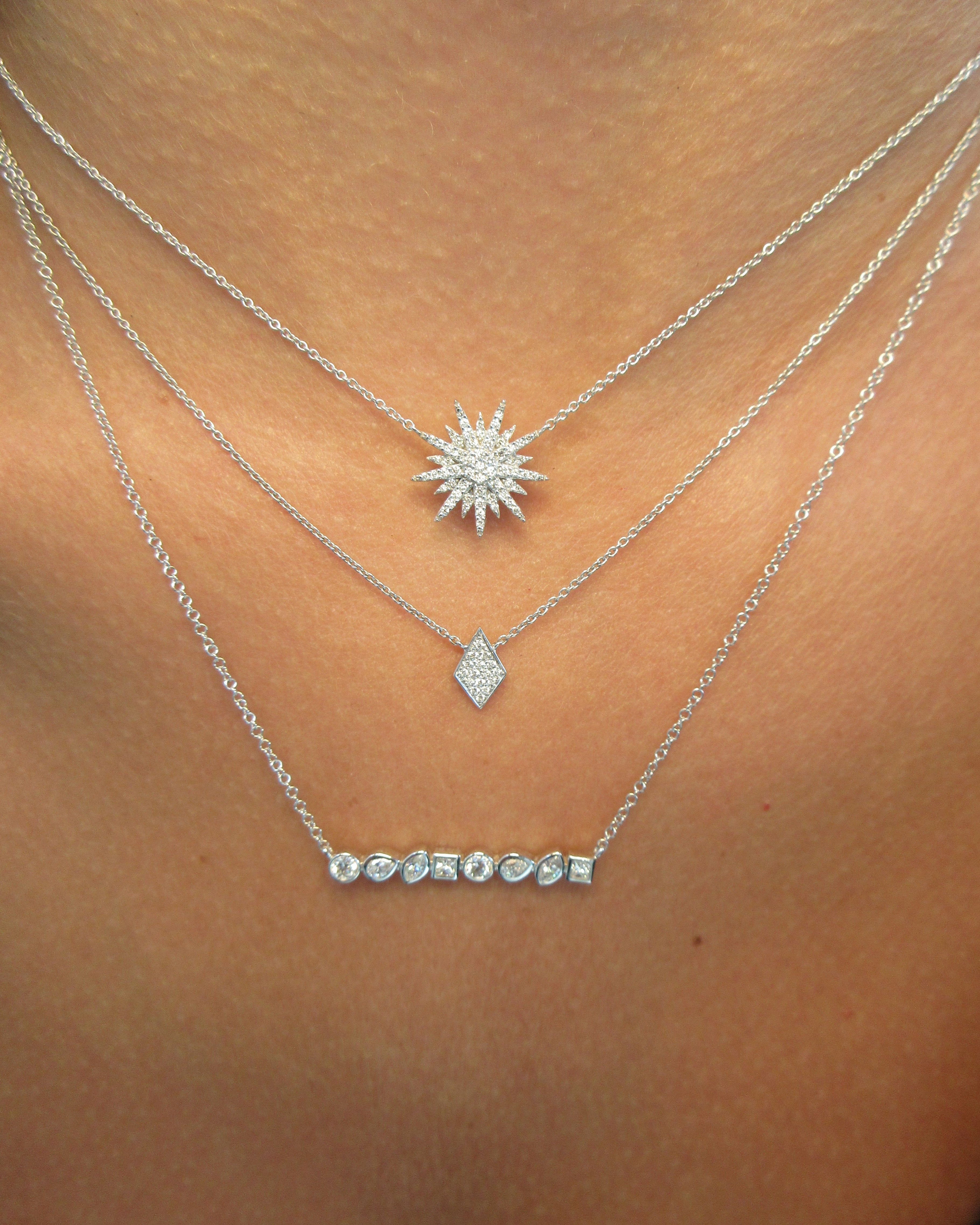 Silver body chain with star and heart designs on a person's shoulder.