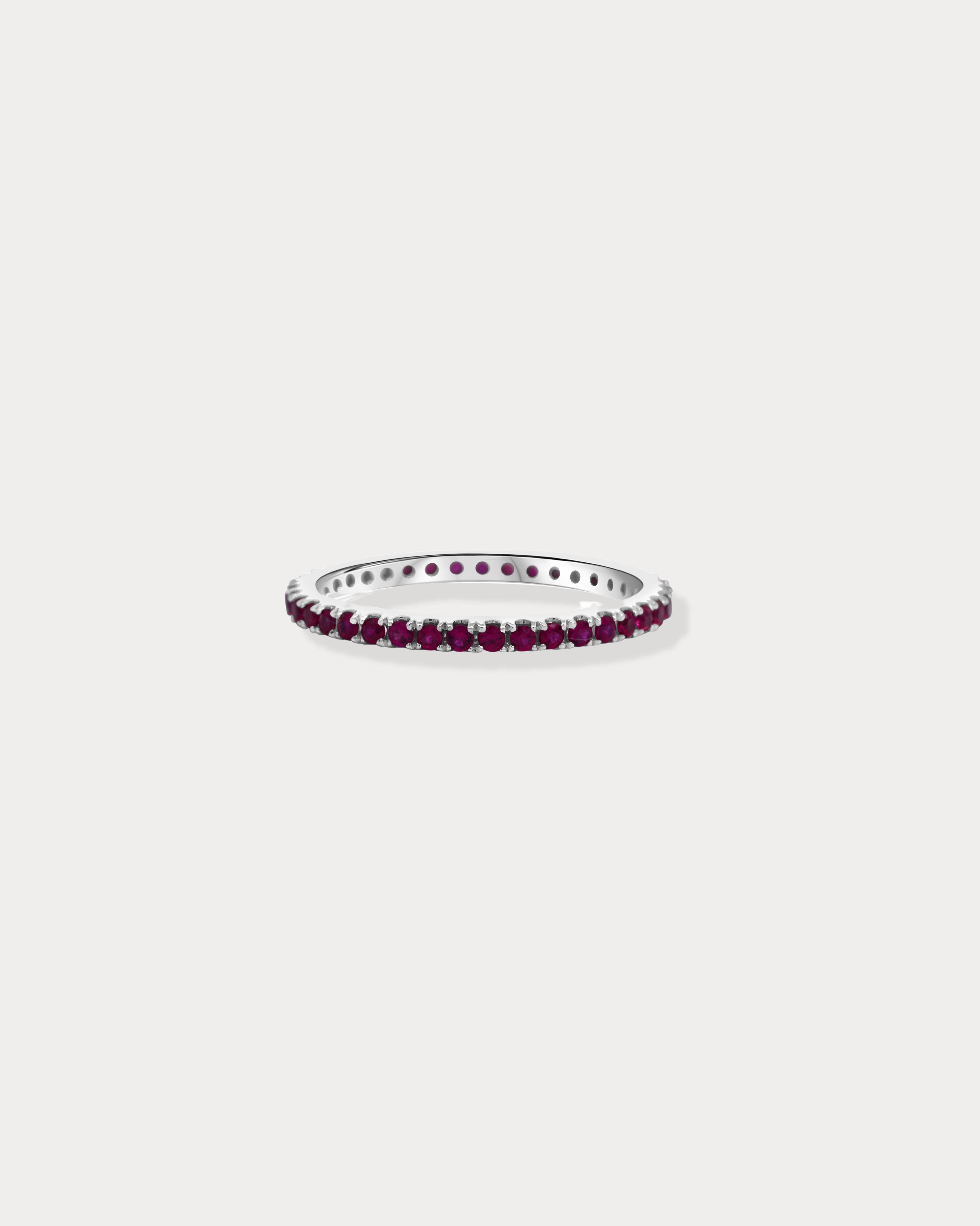 A band of round-cut rubies set in a continuous row around a gold ring