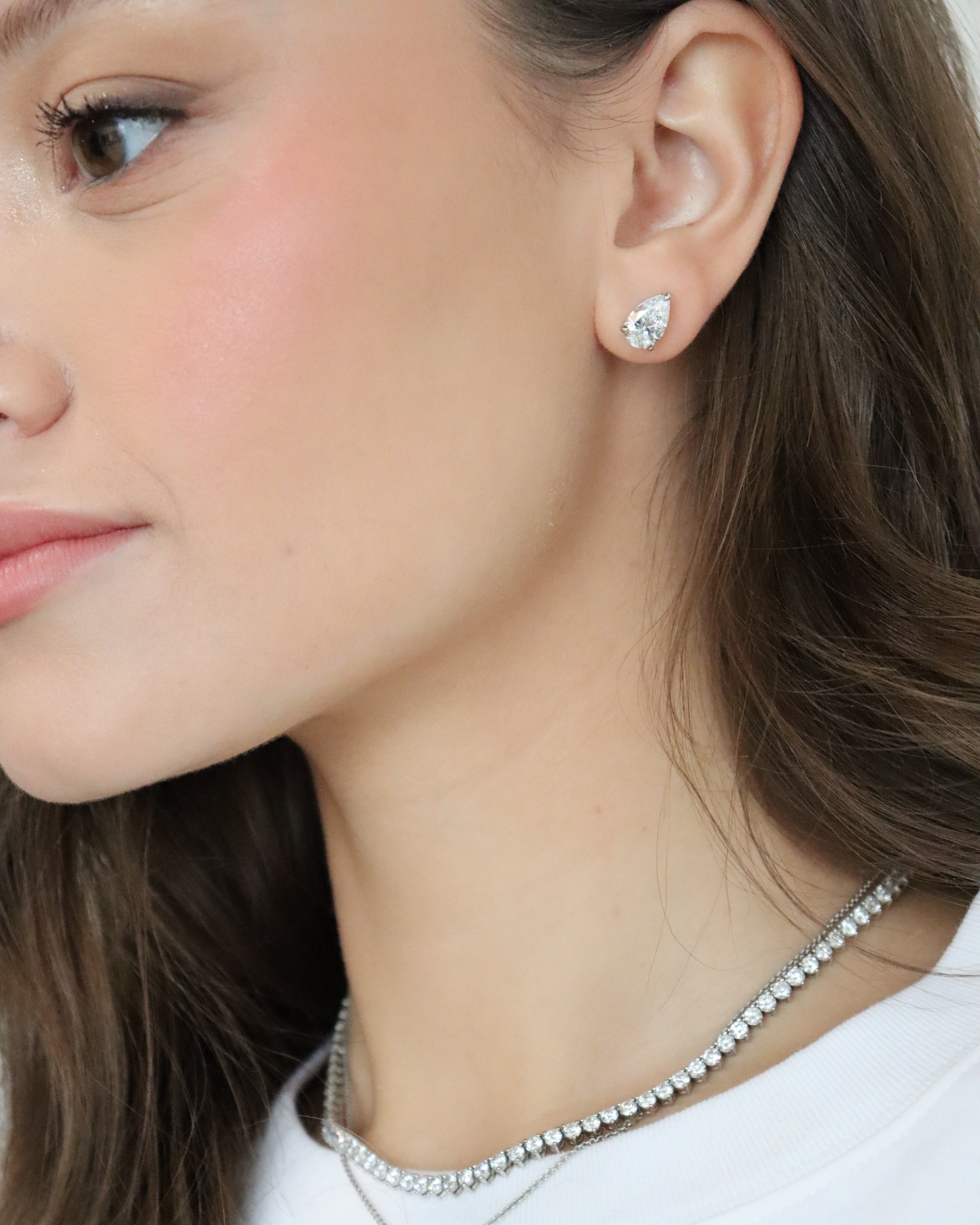 Close-up of a woman wearing a necklace and earring.
