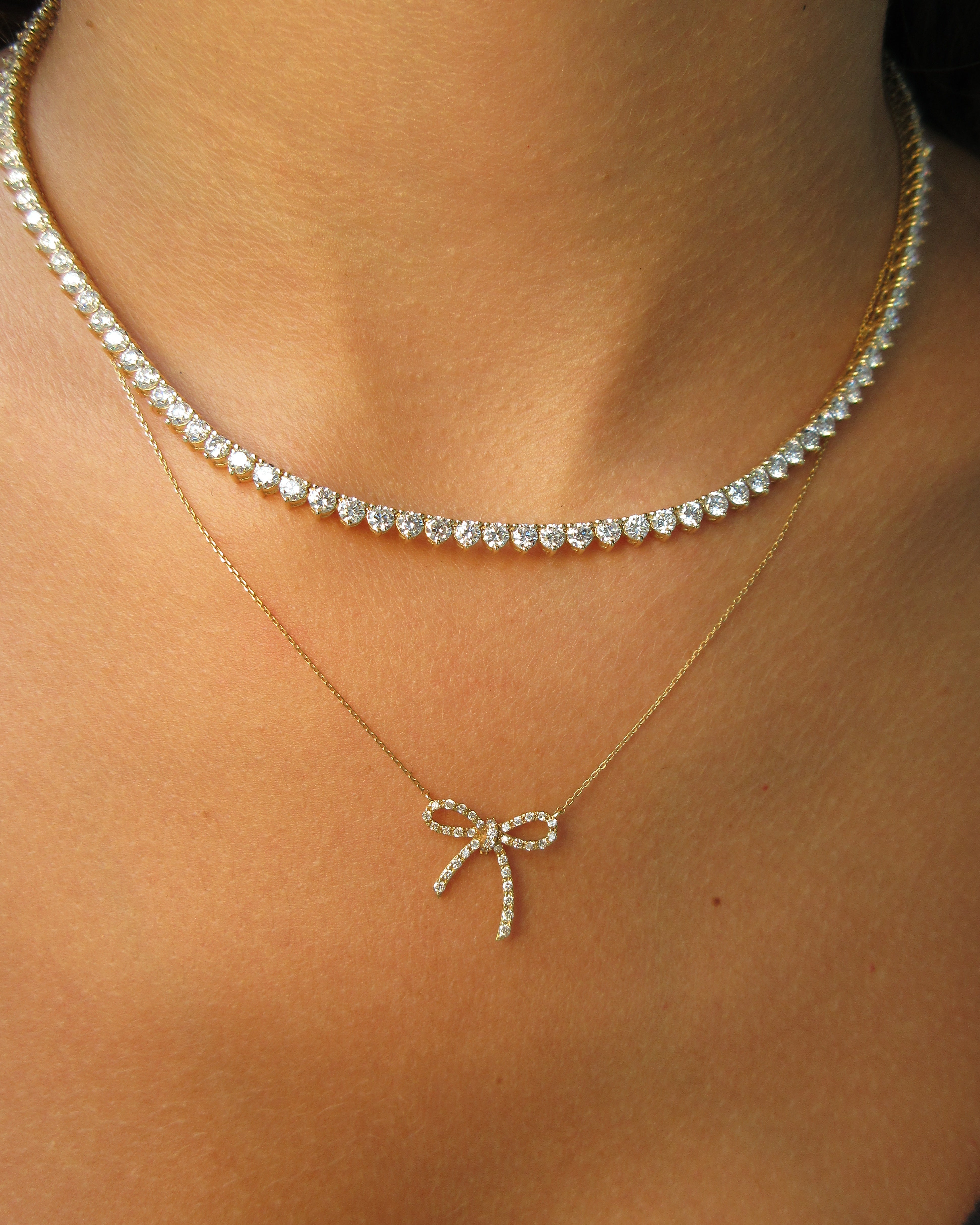 Necklace with a bow-shaped pendant on a person's neck