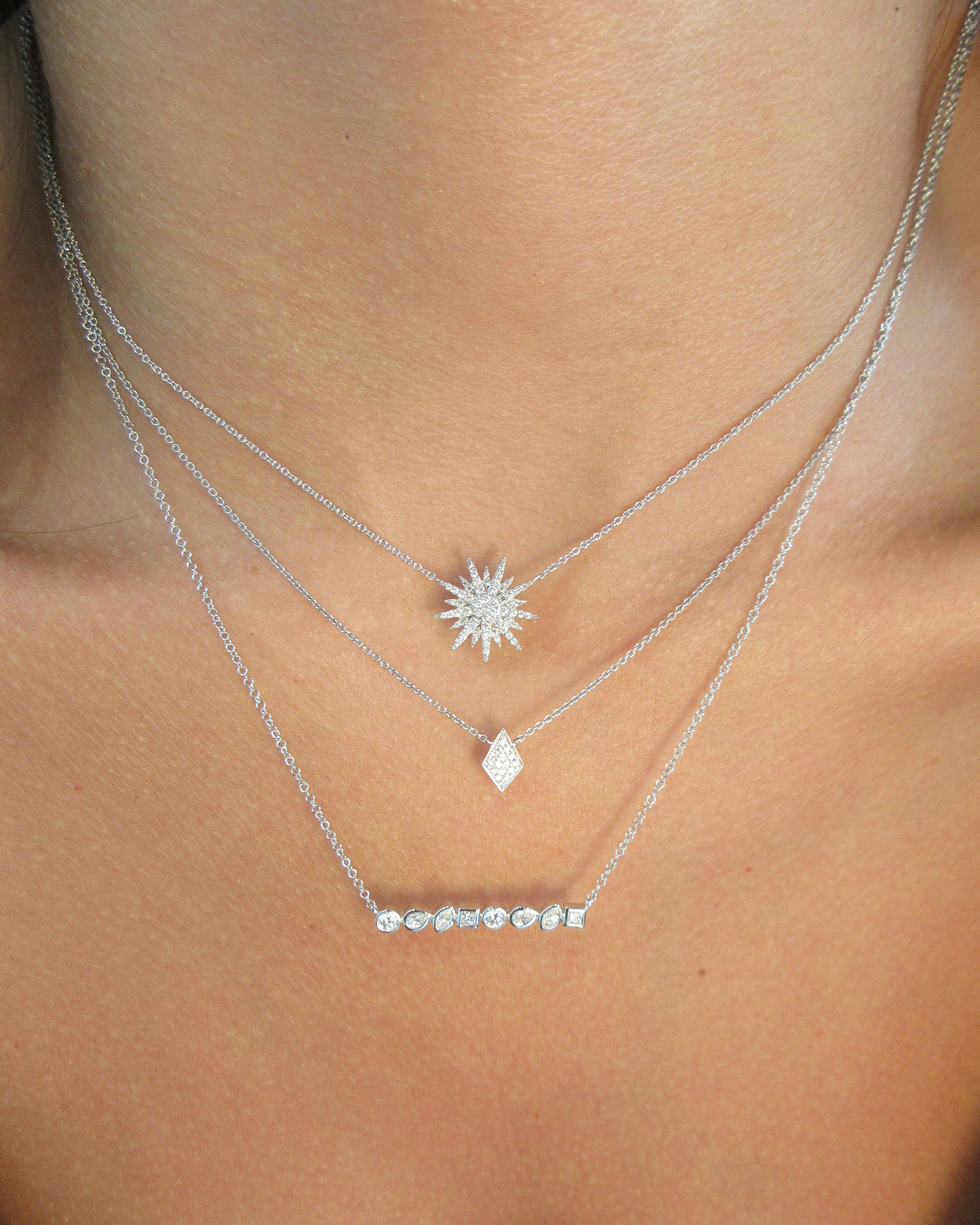 Silver body chain with star and diamond designs on a person's shoulder.