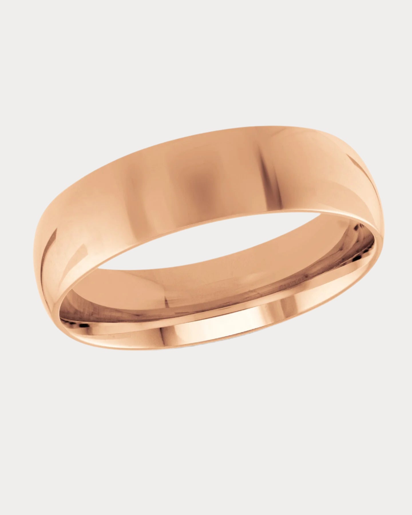 Rose gold wedding band on a light beige background